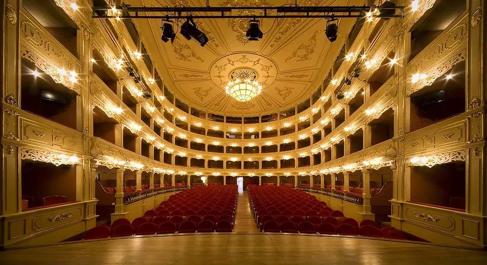Interior d’un teatre d’època amb llotges i butaques vermelles