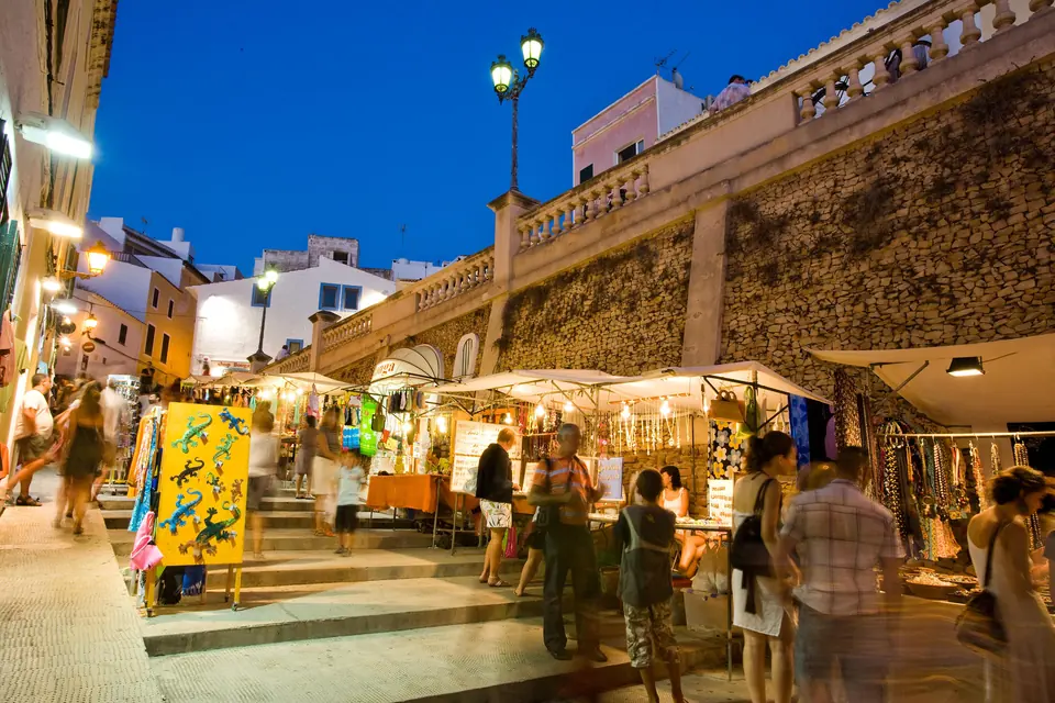 Marché nocturne avec des étals dans une rue près d’un escalier