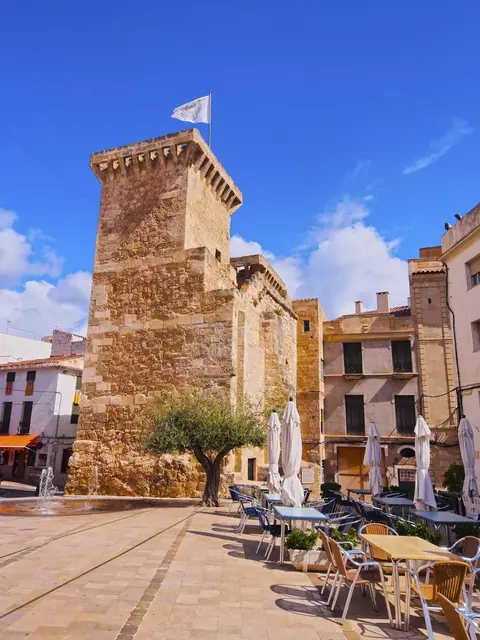 Tour de pierre et façades sur une place de village