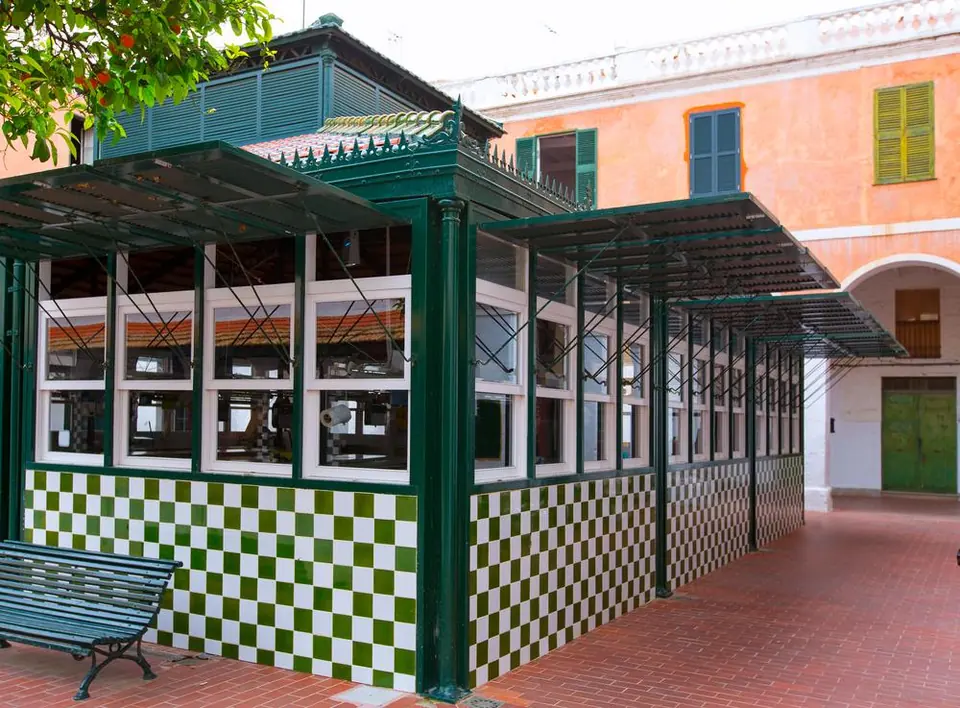 Mercat amb estructura de ferro i vidre i terra de quadres verds i blancs