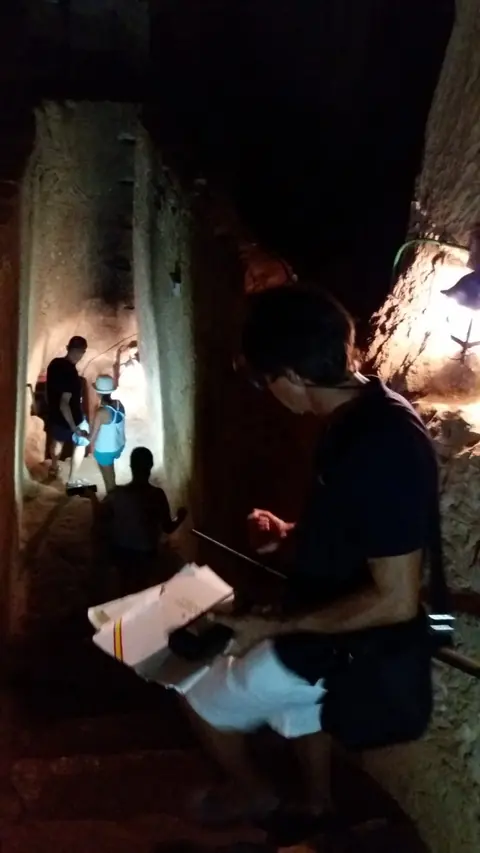 Visitant amb llanterna en una cavitat fosca