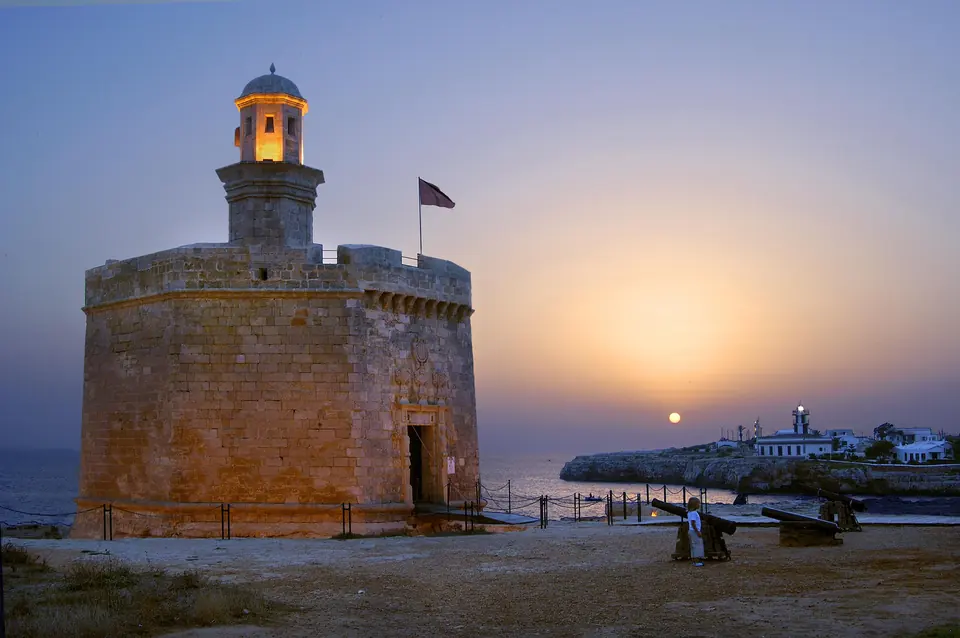 Castell de pedra vora el mar a la posta de sol