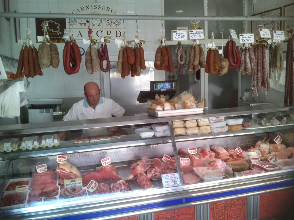 Charcuterie avec saucisses suspendues et un étal de viande
