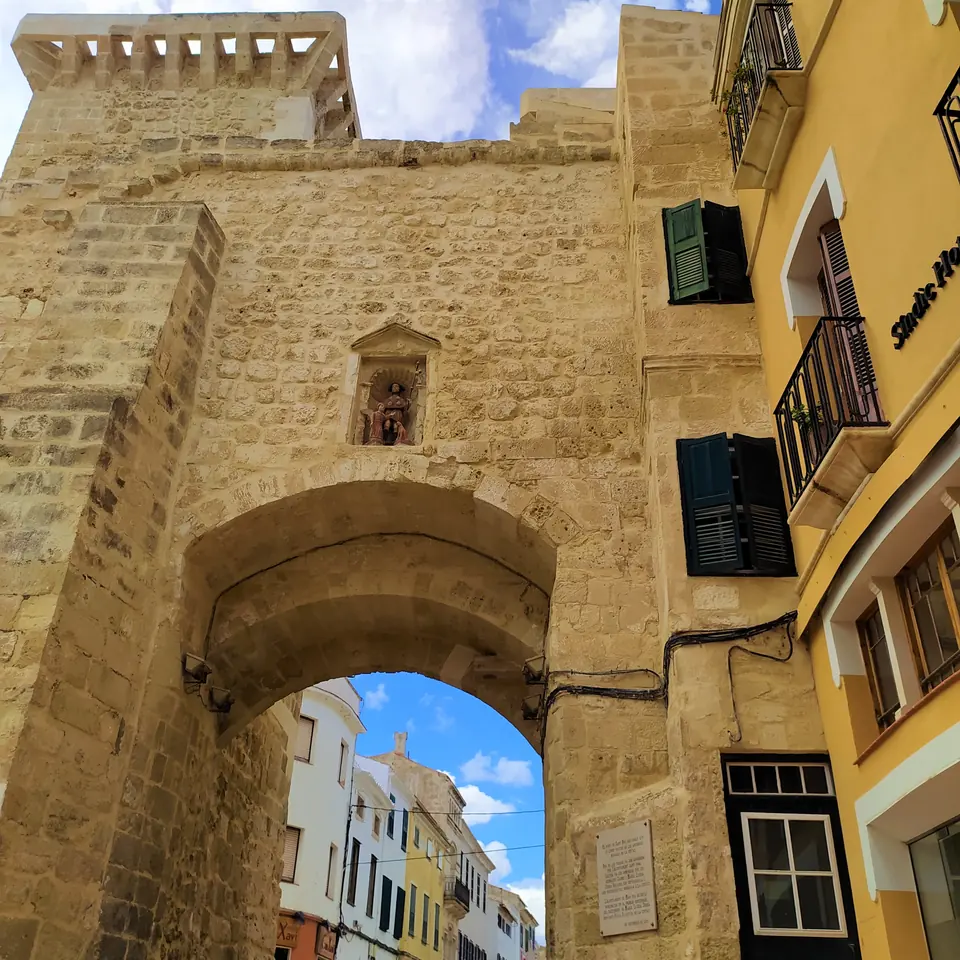 Portal de pedra en un nucli antic amb un carrer al fons