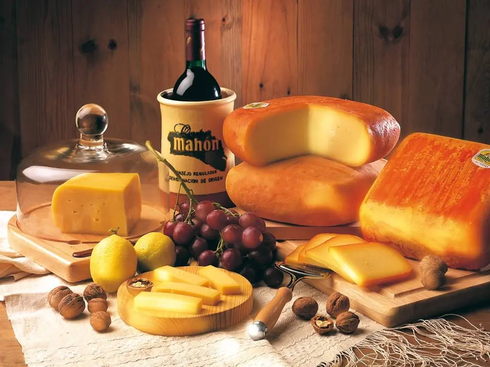 Fromages de Mahón avec du raisin et une bouteille de vin